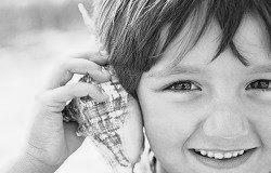 Junge hält sich Muschel ans Ohr